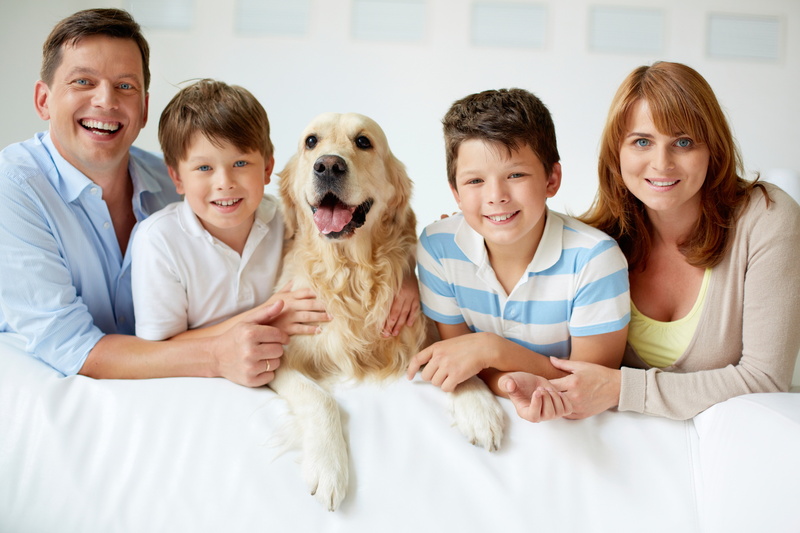 Portrait of happy family with their pet looking at camera